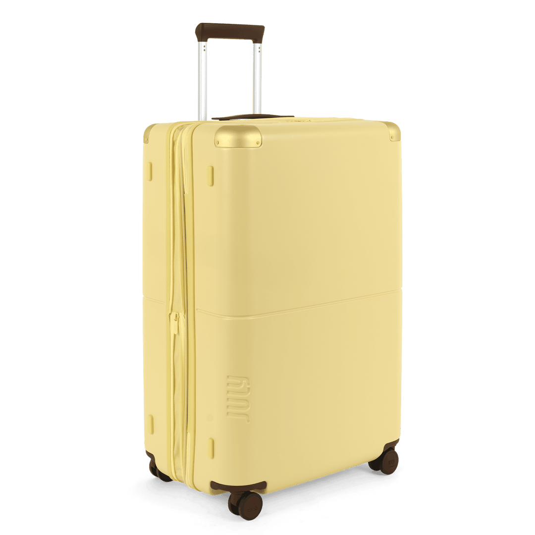 Limone yellow expandable hard-shell checked luggage, front view on white background