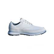 White golf shoe and ball on a green grass field with a flag in the background