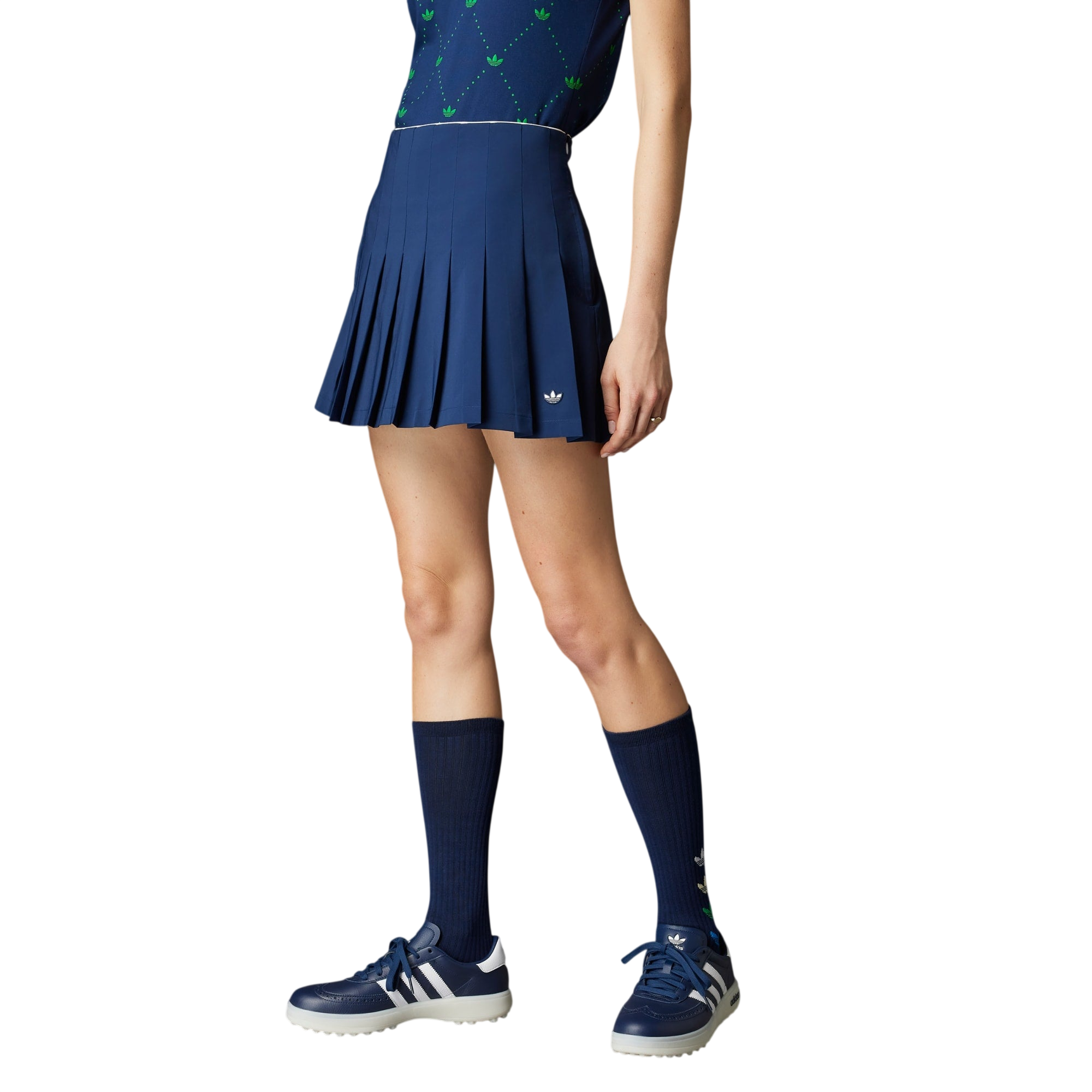 Person wearing a blue tennis outfit with skirt, top, socks, and shoes on a gray background