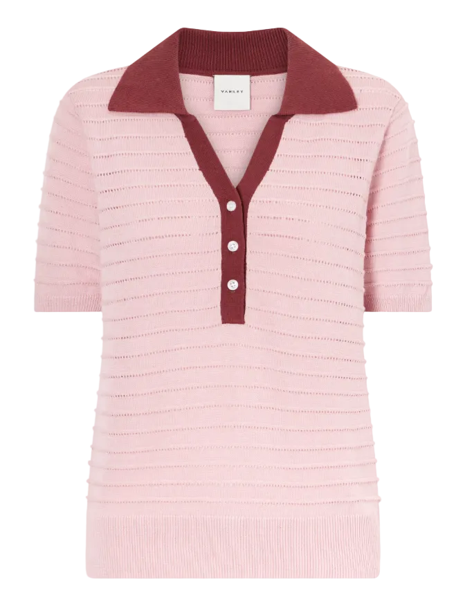 Pink knitted polo shirt with a maroon collar on a light gray background