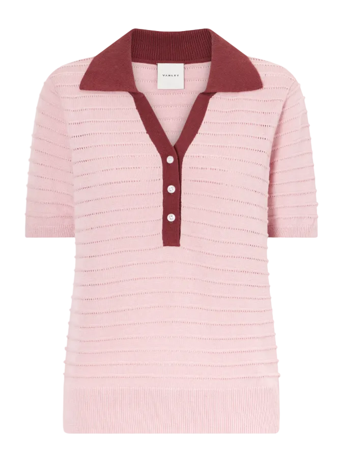 Pink knitted polo shirt with a maroon collar on a light gray background
