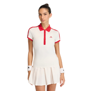 Woman wearing a white and red tennis outfit with an Adidas logo on a light gray background
