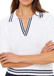 Woman wearing a white polo shirt with blue accents on a plain background