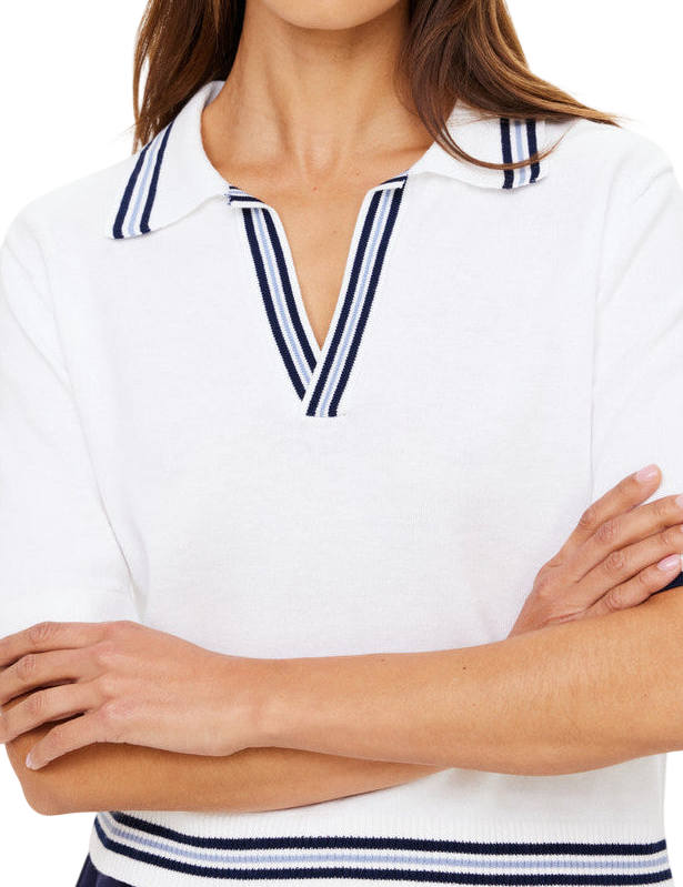 Woman wearing a white polo shirt with blue accents on a plain background