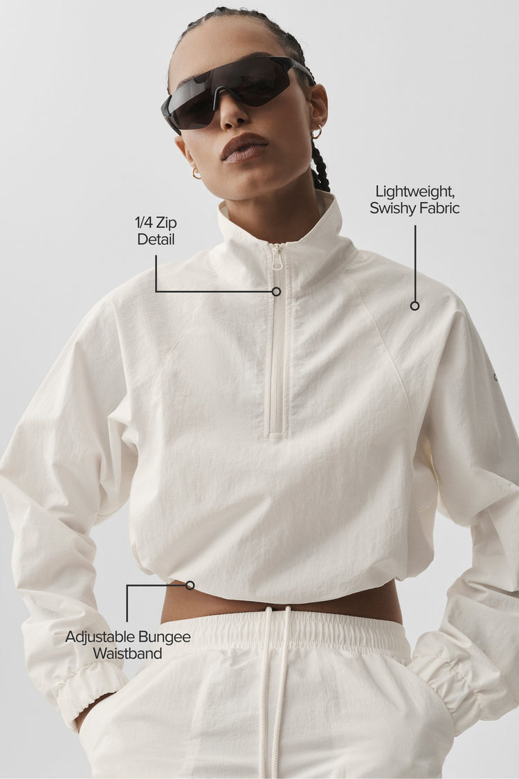Model wearing Alo Yoga Cropped 1/4 Zip Alumni Pullover in ivory