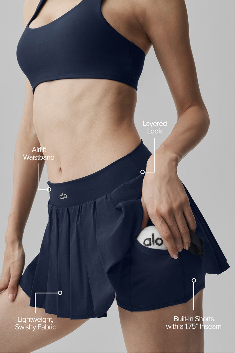 Model wearing Alo Yoga Double Or Nothing Tennis Skirt in navy