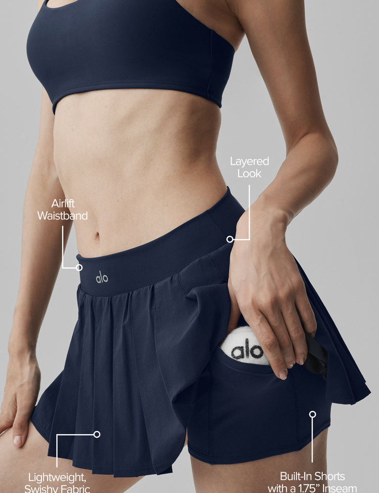 Model wearing Alo Yoga Double Or Nothing Tennis Skirt in navy