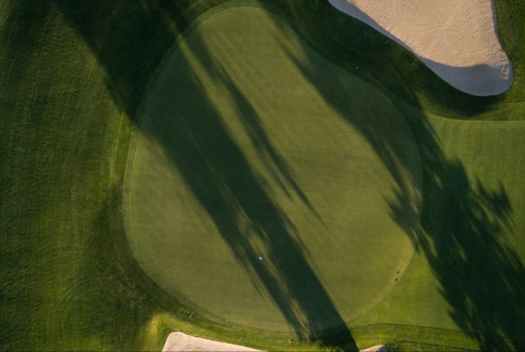 Golf course with sand bunkers and trees from an aerial perspective
