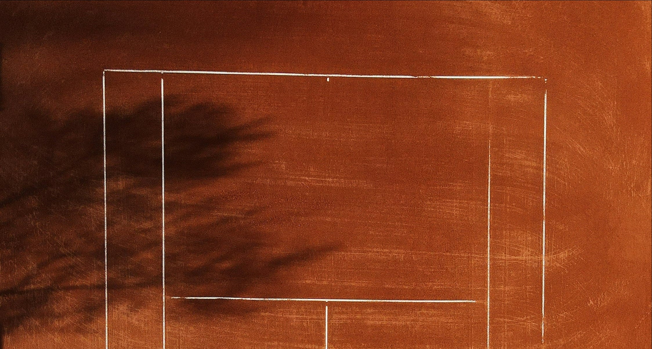 Tennis court with white lines on a brown surface