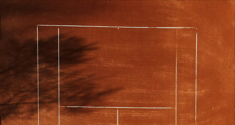 Tennis court with white lines on a brown surface