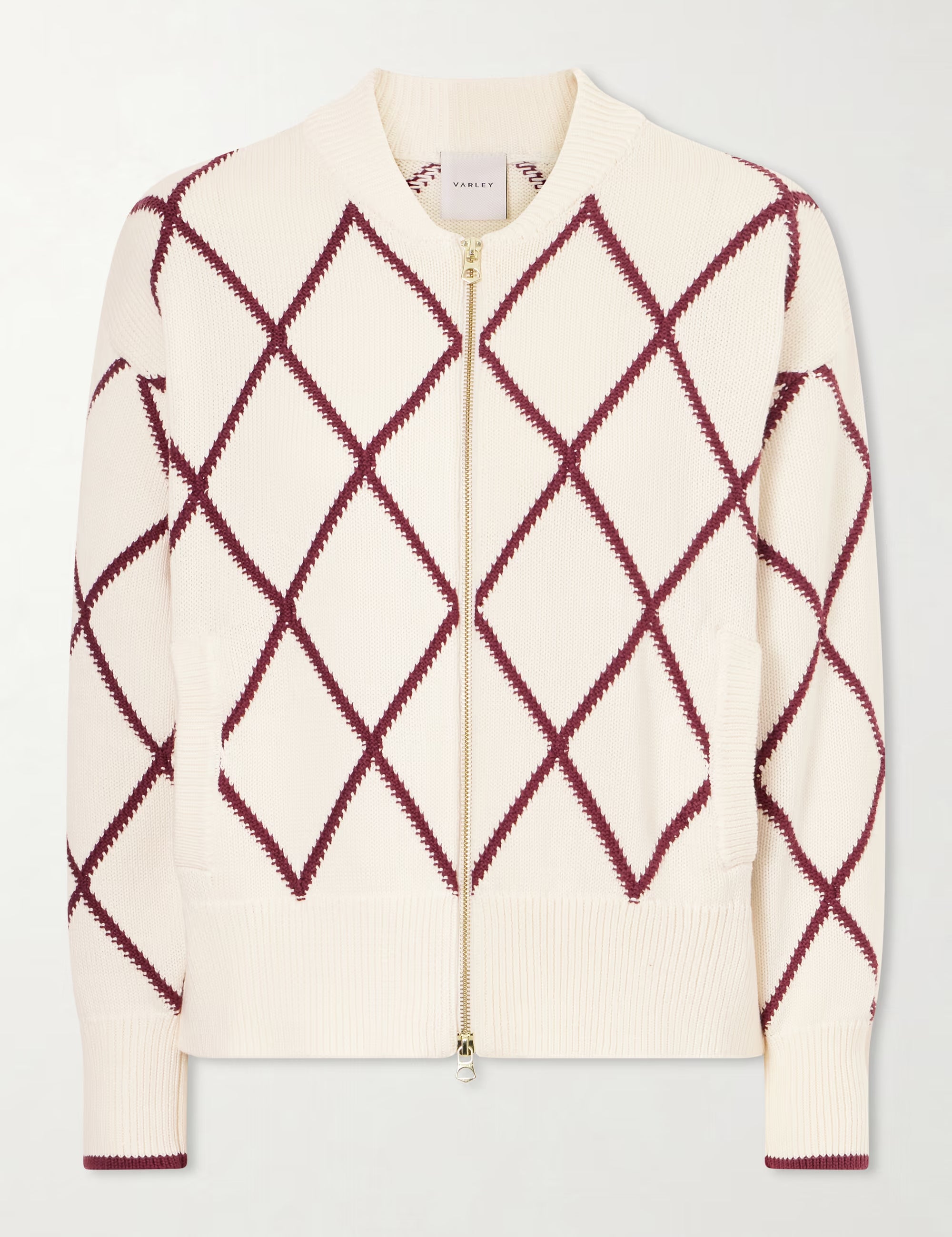 Cream-colored sweater with red diamond pattern on a light gray background