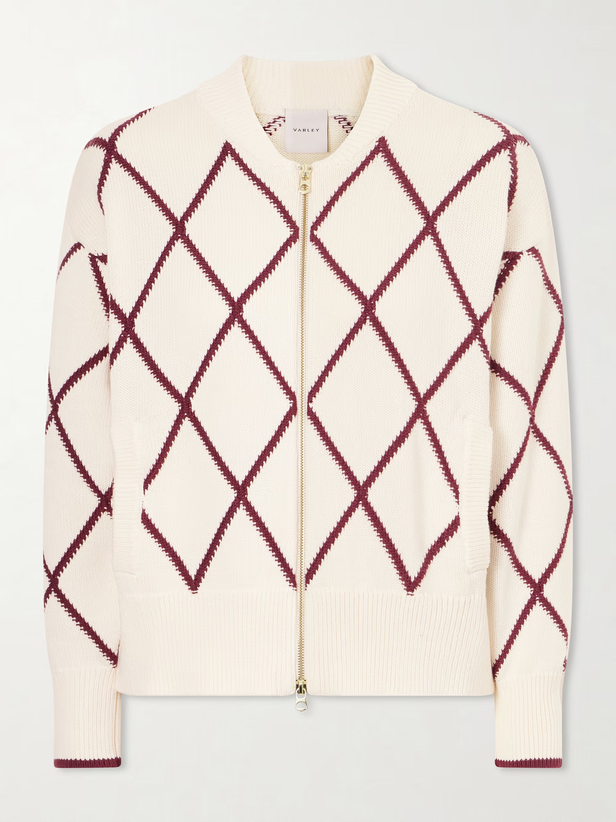 Cream-colored sweater with red diamond pattern on a light gray background