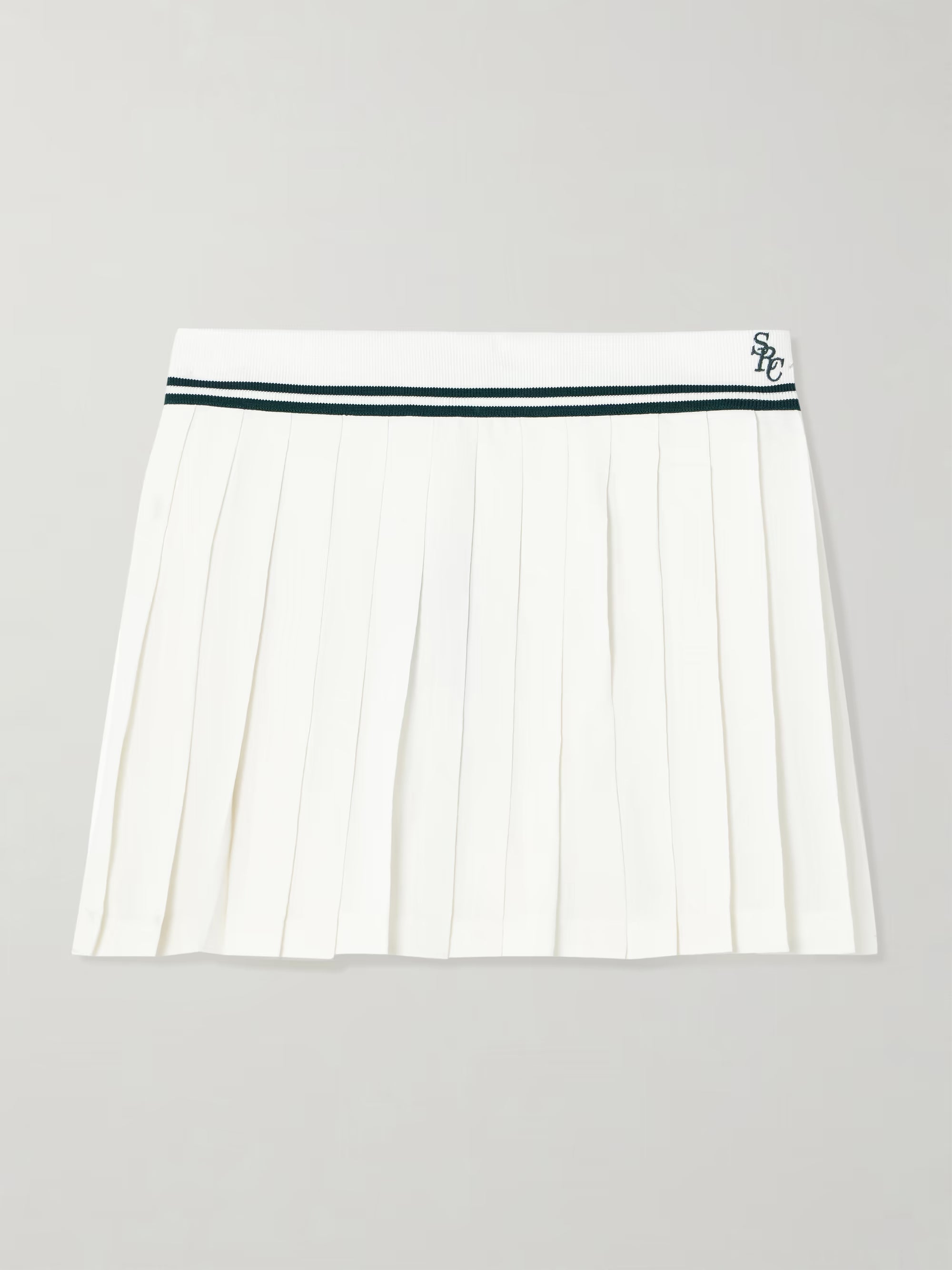 White pleated skirt with a green waistband on a light gray background